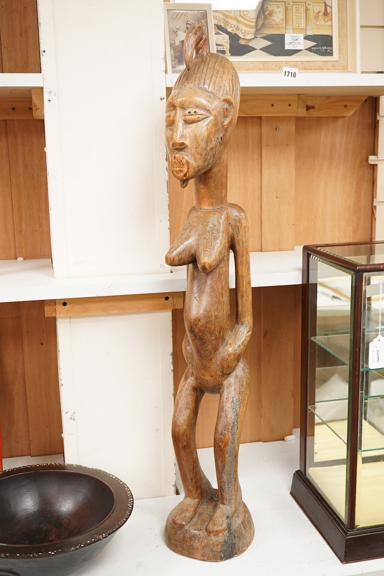 A Fijian carved wood Kava bowl and a West African Dogon fertility figure, 91cm tall